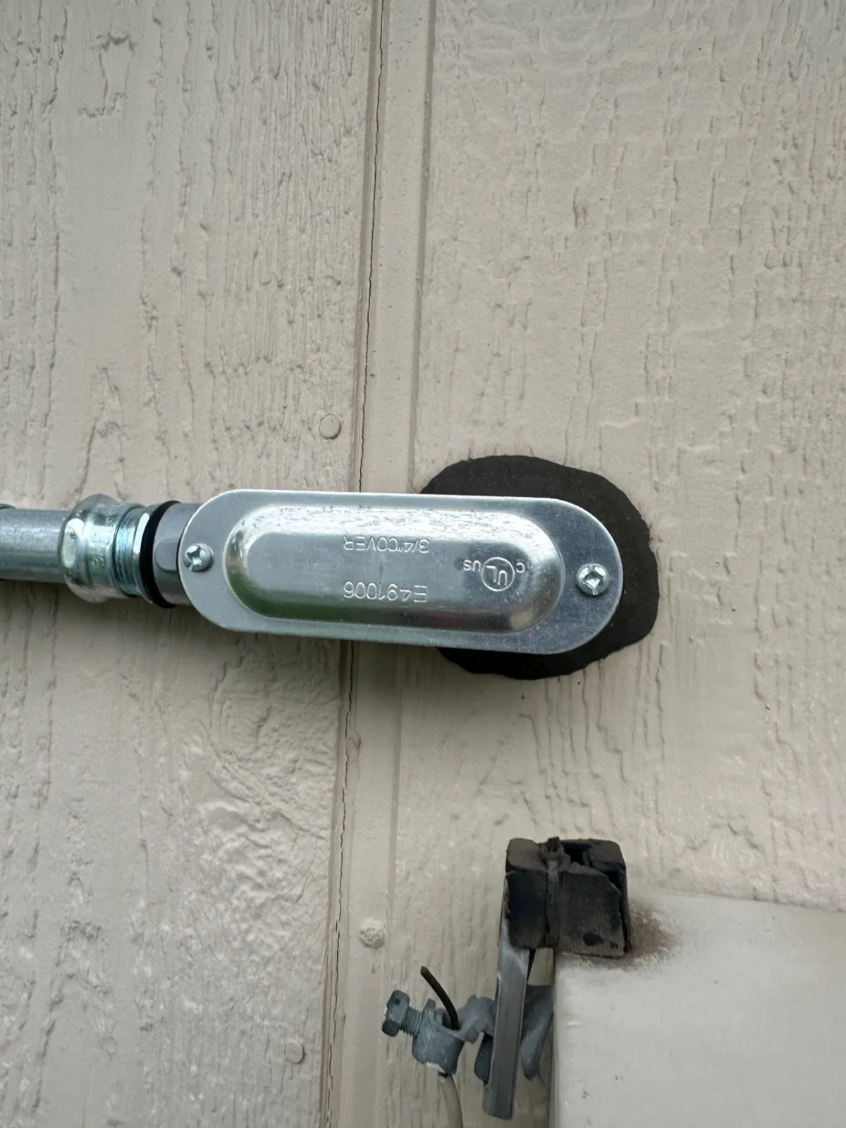 Conduit body at the exterior wall penetration, one of the sealing and weatherproofing points flagged during the audit